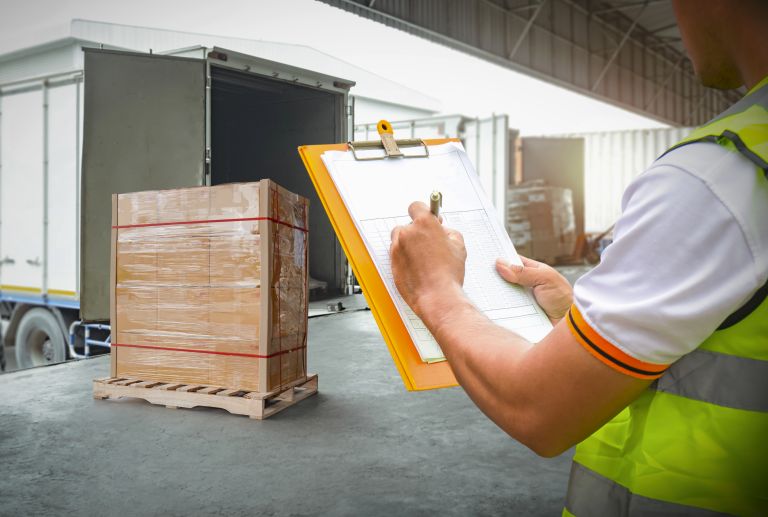 worker-holds-clipboard-controlling-loading-cargo-into-shipping-containers-logistics-trucks